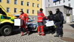 Předání respirátorů od policistů záchranářům
